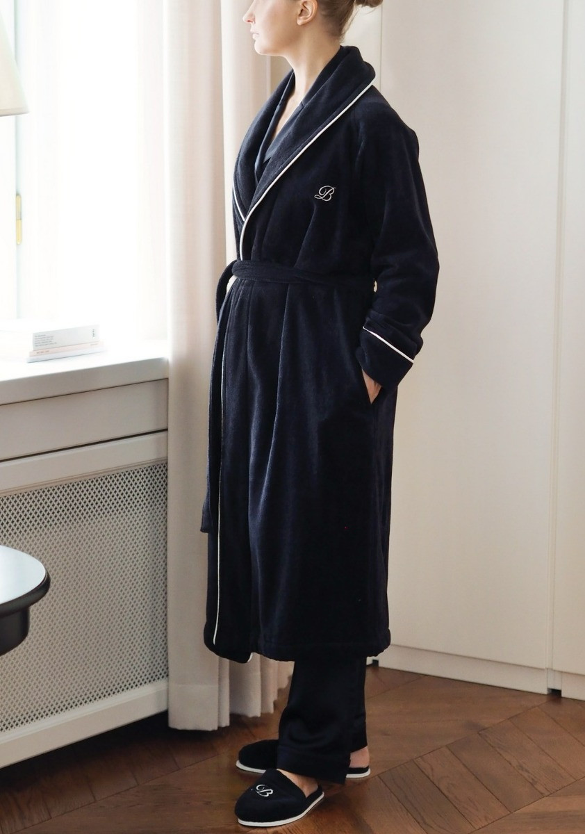 balmuir_portofino_robe_darknavy Der Bademantel Portofino besteht aus 100 % Baumwolle. Das Bademantel-Design zeichnet sich durch einen markanten Schalkragen und einen passenden Gürtel aus. Es ist mit Paspeldetails am Schalkragen und an den Ärmeln sowie einem raffiniert gestickten Markenlogo versehen. Unsere Portofino-Bademäntel werden in Portugal in perfekter Handarbeit gefertigt.