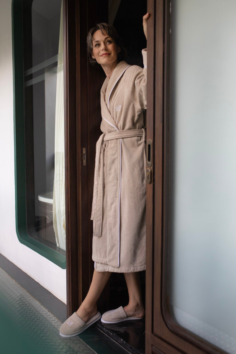 balmuir_portofino_robe_darktaupe_2 Der Bademantel Portofino besteht aus 100 % Baumwolle. Das Bademantel-Design zeichnet sich durch einen markanten Schalkragen und einen passenden Gürtel aus. Es ist mit Paspeldetails am Schalkragen und an den Ärmeln sowie einem raffiniert gestickten Markenlogo versehen. Unsere Portofino-Bademäntel werden in Portugal in perfekter Handarbeit gefertigt.