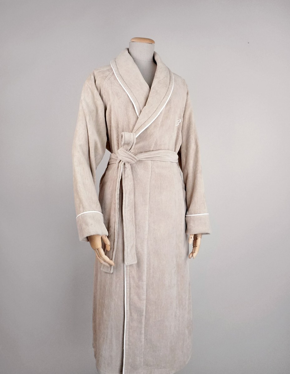 balmuir_portofino_robe_darktaupe_closeup_web Der Bademantel Portofino besteht aus 100 % Baumwolle. Das Bademantel-Design zeichnet sich durch einen markanten Schalkragen und einen passenden Gürtel aus. Es ist mit Paspeldetails am Schalkragen und an den Ärmeln sowie einem raffiniert gestickten Markenlogo versehen. Unsere Portofino-Bademäntel werden in Portugal in perfekter Handarbeit gefertigt.